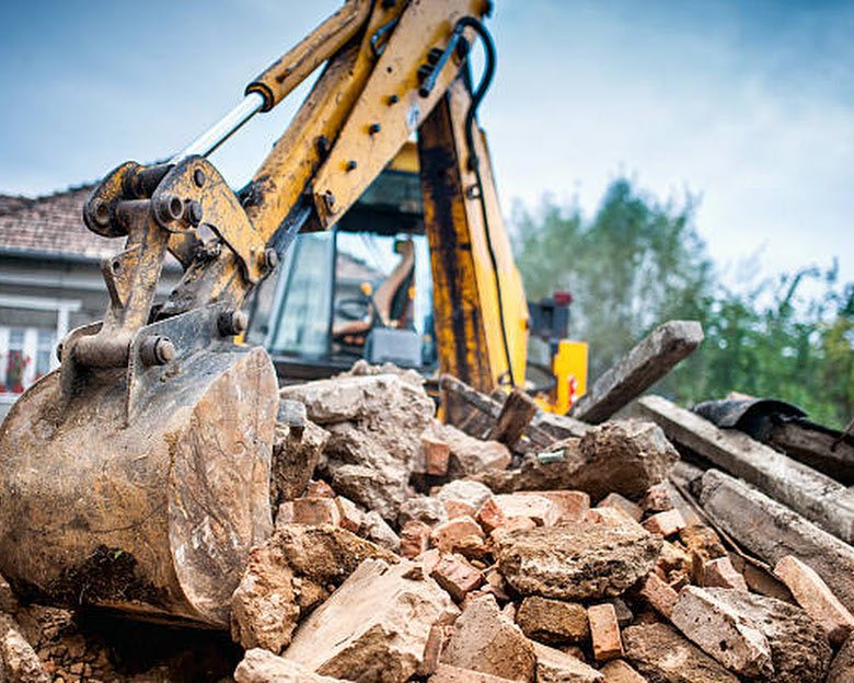 Excavator moving rubble on a site.